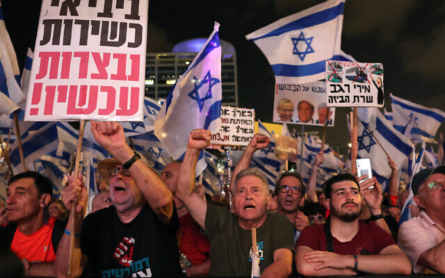 Des manifestants brandissant des drapeaux et des pancartes lors d'une manifestation contre le plan de refonte judiciaire du gouvernement israélien, à Tel Aviv, le 26 août 2023. (Crédit : Jack Guez/AFP) Des manifestants brandissant des drapeaux et des pancartes lors d'une manifestation contre le plan de refonte judiciaire du gouvernement israélien, à Tel Aviv, le 26 août 2023. (Crédit : Jack Guez/AFP)