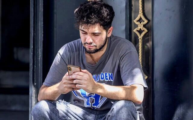 Une personne tient un téléphone à Téhéran, le 11 septembre 2023. (Crédit : ATTA KENARE / AFP)