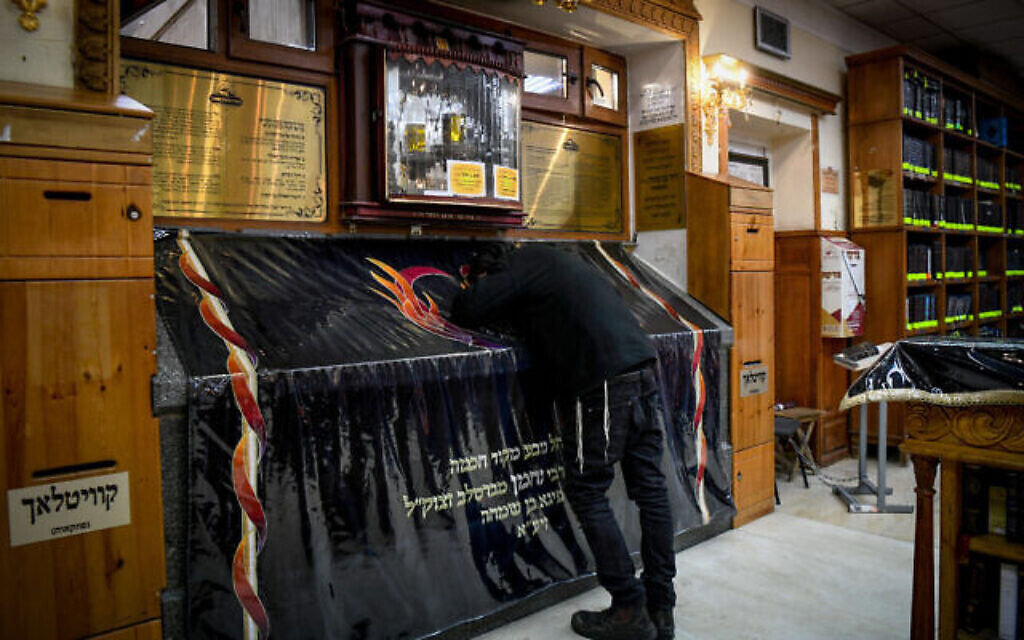Un homme juif priant sur la tombe de Rabbi Nachman de Breslov, dans la ville d'Ouman, dans le centre de l'Ukraine, le 26 janvier 2022. (Crédit : Yossi Zeliger/Flash90)