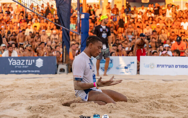 Pablo Santos prie après avoir marqué un point lors d'un match de footvolley sur la plage Frishman de Tel Aviv, le 29 juillet 2023. (Crédit : Chaim Weingarten)