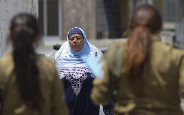 Illustration : Une femme arabe israélienne passant devant des soldates israéliennes. (Credit : Ariel Schalit/AP/Dossier) Illustration : Une femme arabe israélienne passant devant des soldates israéliennes. (Credit : Ariel Schalit/AP/Dossier)
