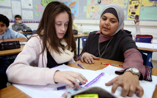 Nedaa Rabie, enseignante arabo-israélienne, aidant l'élève Adi Hevlin dans sa classe au collège Gvanim à Qadima, le 26 décembre 2013. (Crédit : Hadas Parush/Flash 90)