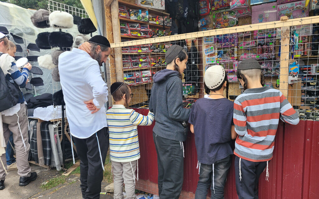 Ofer Azran, à gauche, attendant que son fils choisisse un portefeuille à Ouman, en Ukraine, le 15 septembre 2023. (Crédit : Canaan Lidor/Times of Israel)
