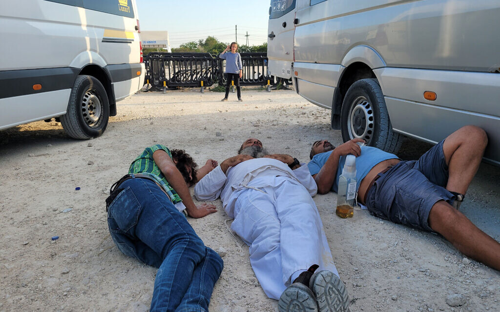 Un garçon regardant trois pèlerins israéliens dormir près de leur mini van à Palanca, en Moldavie, le 14 septembre 2023. (Crédit : Canaan Lidor/Times of Israel)