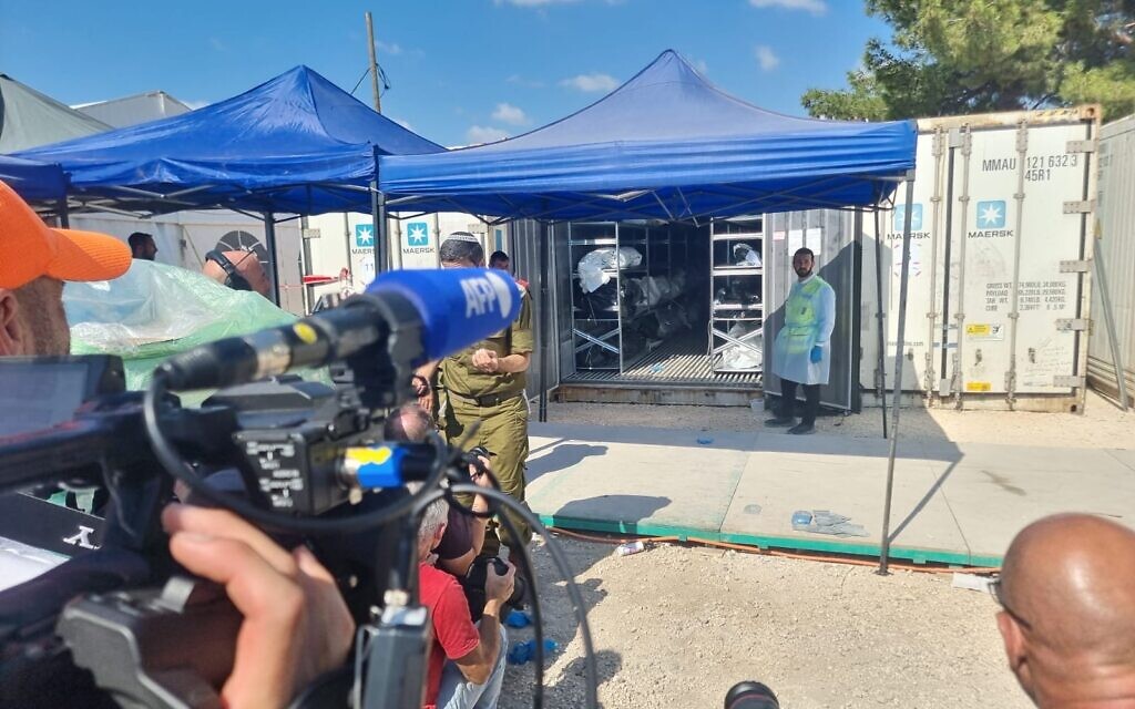Un volontaire de Zaka devant des conteneurs servant de morgue temporaire pour les victimes de l'attaque du Hamas du 7 octobre, au siège du rabbinat militaire à Ramle, le 13 octobre 2023. (Crédit : GPO) Un volontaire de Zaka devant des conteneurs servant de morgue temporaire pour les victimes de l'attaque du Hamas du 7 octobre, au siège du rabbinat militaire à Ramle, le 13 octobre 2023. (Crédit : GPO)