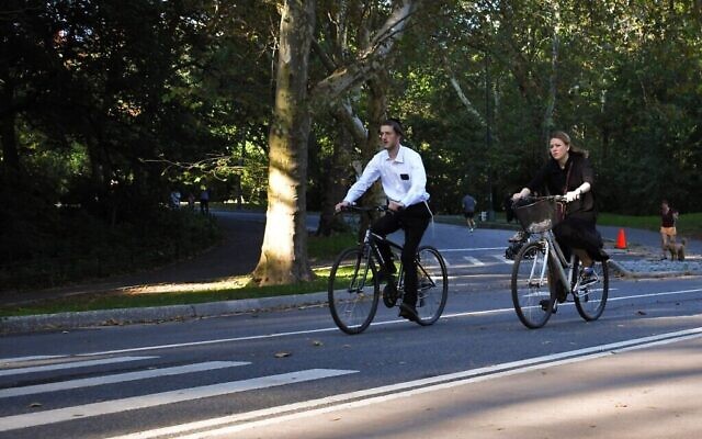 Un jeune couple à vélo dans Central Park, le premier jour de Chol Hamoed Sukkot 2023. (Crédit : Jackie Hajdenberg/JTA)