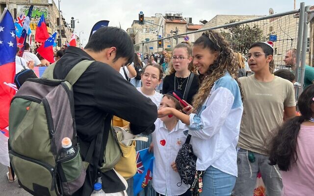 Des Israéliens reçoivent des cadeaux lors de la marche de l'ambassade chrétienne internationale de Jérusalem, le 4 octobre 2023 (Crédit : Lazar Berman/The Times of Israel)