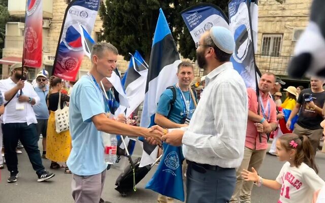 Un Israélien serre la main de sionistes estoniens lors de la marche de l'ambassade chrétienne internationale de Jérusalem, le 4 octobre 2023 (Crédit : Lazar Berman/The Times of Israel)