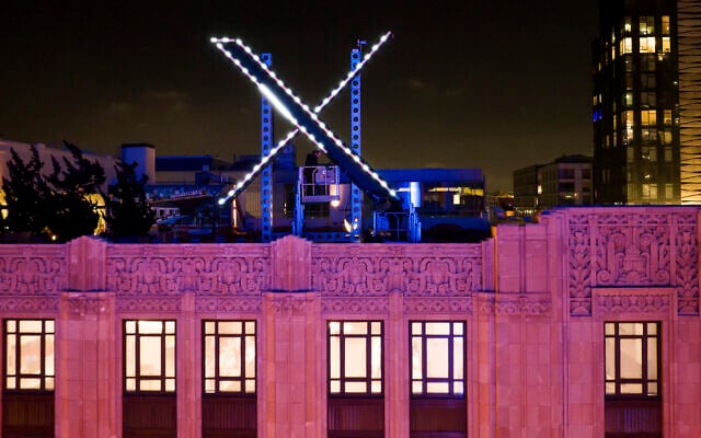 Des ouvriers installent un éclairage sur un signe "X" au sommet du siège de l'entreprise, anciennement connue sous le nom de Twitter, dans le centre-ville de San Francisco, le 28 juillet 2023. (Crédit : Noah Berger/AP) Des ouvriers installent un éclairage sur un signe "X" au sommet du siège de l'entreprise, anciennement connue sous le nom de Twitter, dans le centre-ville de San Francisco, le 28 juillet 2023. (Crédit : Noah Berger/AP)