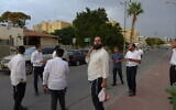 Daniel Mualem, muni d'un sac en plastique, regardant la maison de Rachel et David Edry à Ofakim, le 9 octobre 2023. (Crédit : Canaan Lidor/Times of Israel)