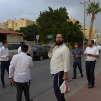 Daniel Mualem, muni d'un sac en plastique, regardant la maison de Rachel et David Edry à Ofakim, le 9 octobre 2023. (Crédit : Canaan Lidor/Times of Israel)