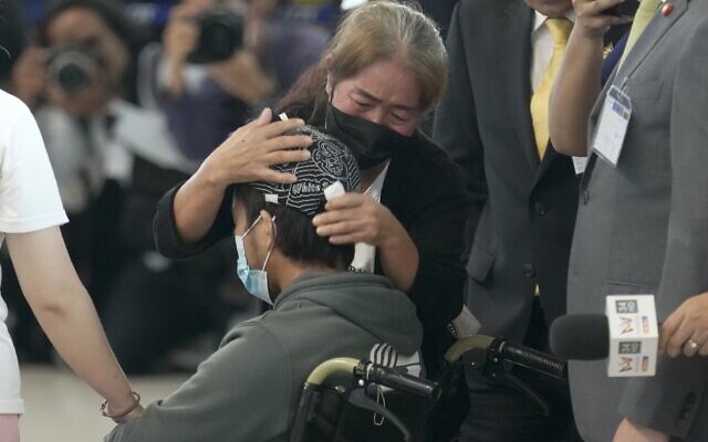 Un parent serre dans ses bras un travailleur thaïlandais évacué d'Israël, à son arrivée à l'aéroport international Suvarnabhumi, dans la province de Samut Prakarn, en Thaïlande, le 12 octobre 2023. (Crédit : Sakchai Lalit/AP)