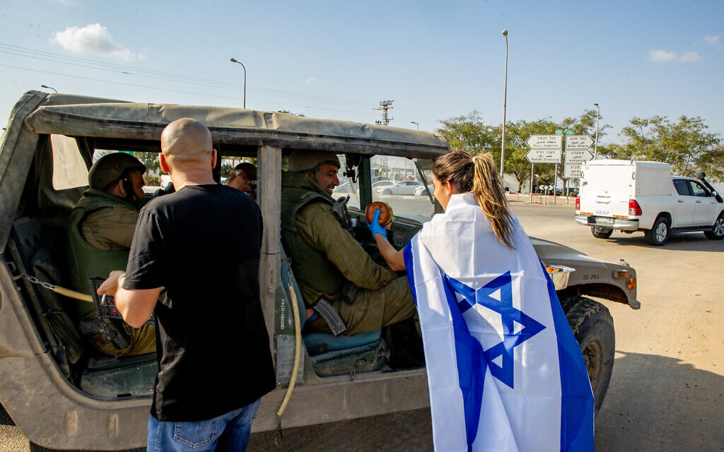 Des Israéliens distribuent de la nourriture aux soldats près de la frontière avec la bande de Gaza, dans le sud d'Israël, le 11 octobre 2023. (Crédit : Oren Ben Hakoon/Flash90)