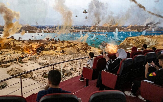 Spectateurs d'une scène de guerre recréée au musée et mémorial de la guerre israélo-arabe de 1973 au Caire, en Égypte, le 1er octobre 2023. (Crédit : Khaled DESOUKI/AFP) Spectateurs d'une scène de guerre recréée au musée et mémorial de la guerre israélo-arabe de 1973 au Caire, en Égypte, le 1er octobre 2023. (Crédit : Khaled DESOUKI/AFP)