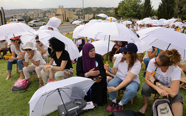 Des activistes de diverses ONG locales et étrangères rassemblées autour du monument de la tolérance dans un parc de Jérusalem, alors qu'elles participent à un événement conjoint organisé par les mouvements israélien Women Wage Peace et palestinien Women of the Sun, demandant la fin du cycle de l'effusion de sang et une solution au conflit israélo-palestinien, le 4 octobre 2023. (Crédit : Menahem Kahana/AFP) Des activistes de diverses ONG locales et étrangères rassemblées autour du monument de la tolérance dans un parc de Jérusalem, alors qu'elles participent à un événement conjoint organisé par les mouvements israélien Women Wage Peace et palestinien Women of the Sun, demandant la fin du cycle de l'effusion de sang et une solution au conflit israélo-palestinien, le 4 octobre 2023. (Crédit : Menahem Kahana/AFP)