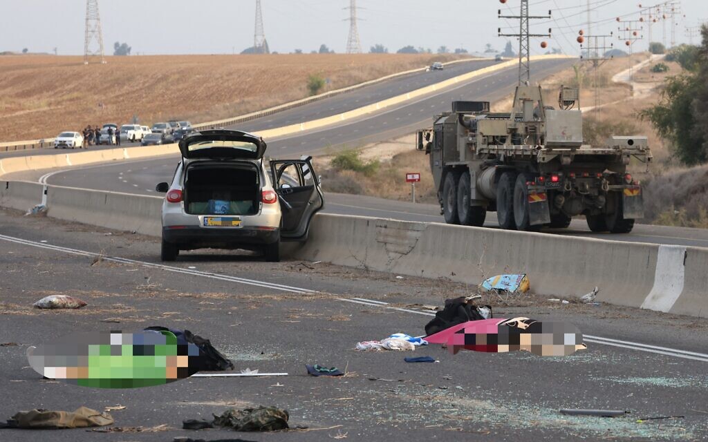 Des corps gisant sur une route principale, suite à une attaque par des terroristes du Hamas, à proximité du kibboutz Gevim, le 7 octobre 2023. (Crédit : Oren Ziv/AFP)