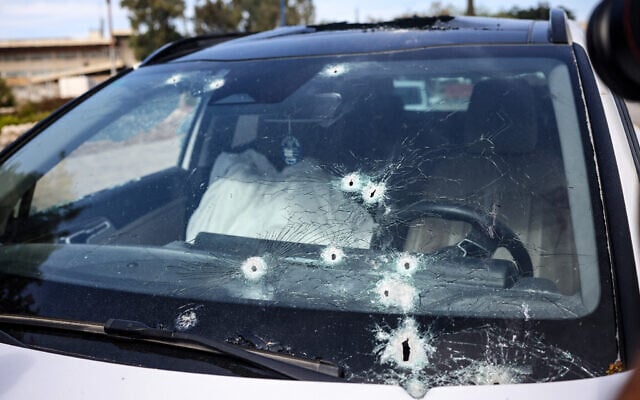 Le corps d'une personne tuée par des terroristes du Hamas gisant dans une voiture criblée de balles dans la ville méridionale de Sderot, le 7 octobre 2023. (Crédit : Oren Ziv/AFP)