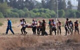 Les équipes de secours israéliennes évacuant un blessé près de la ville de Sderot, dans le sud du pays, le 7 octobre 2023, après que le groupe terroriste palestinien du Hamas a lancé une offensive surprise à grande échelle contre Israël. (Crédit : Menahem Kahana/AFP)