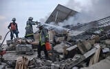 Des pompiers palestiniens éteignant un incendie qui faisait rage dans un bâtiment détruit par des frappes aériennes israéliennes dans la ville de Gaza, le 8 octobre 2023. ( Crédit : Mohammed Abed/AFP)