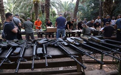 Des Israéliens arrivent à un point de distribution d'armes pour les personnes autorisées à porter des armes, au kibboutz Ayyelet HaShahar, dans le nord d'Israël, près de la frontière libanaise, le 12 octobre 2023. (Crédit : Jalaa MAREY / AFP)