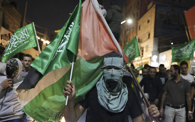 Des partisans des mouvements Fatah et Hamas lors d'une marche dans la ville d'Hébron, en Cisjordanie, le 11 octobre 2023. (Crédit : HAZEM BADER / AFP)