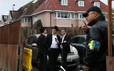 Un agent de sécurité devant une synagogue du nord de Londres, le 13 octobre 2023, après que le gouvernement britannique a annoncé un financement supplémentaire pour la protection des lieux juifs. (Crédit : Daniel LEAL / AFP)