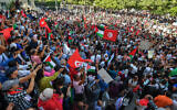 Des manifestants tunisiens brandissant des drapeaux palestiniens et tunisiens lors d'une manifestation anti-Israël, à Tunis, le 12 octobre 2023. (Crédit : Fethi Belaïd/AFP)