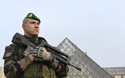 Un soldat montant la garde à l'entrée de la Pyramide du Louvre,  dans le cadre de l'opération Sentinelle, à Paris le 30 décembre 2016. (Crédit : Alain Jocard/AFP)