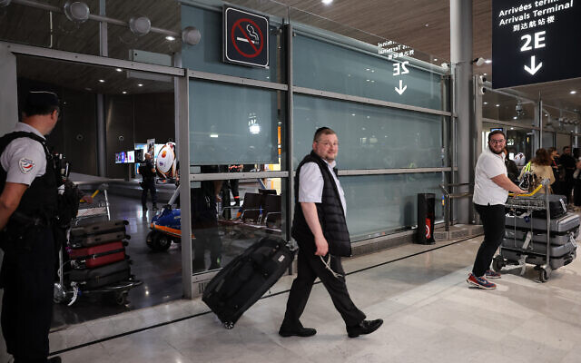 Des passagers de Tel Aviv sur un vol pour ressortissants français, à l'aéroport Roissy-Charles-de-Gaulle, dans la banlieue de Paris, le 12 octobre 2023, alors qu'ils ont été rapatriés à la suite de l'attaque terroriste de la semaine dernière contre Israël par Hamas. (Crédit : Mehdi FEDOUACH / AFP)