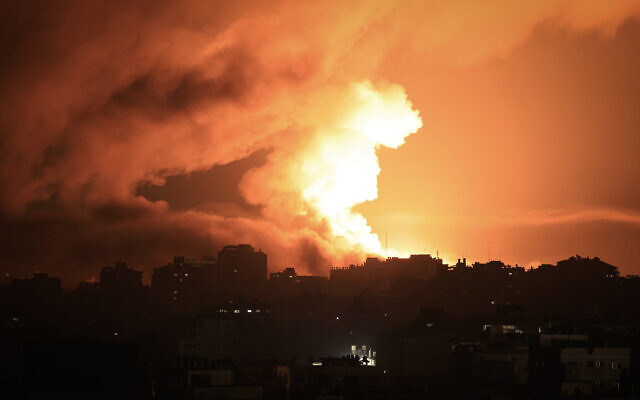Du feu et de la fumée s’élevant au-dessus des bâtiments de la ville de Gaza lors d'une frappe aérienne israélienne, le 13 octobre 2023. (Crédit : Mahmud Hams/AFP) Du feu et de la fumée s’élevant au-dessus des bâtiments de la ville de Gaza lors d'une frappe aérienne israélienne, le 13 octobre 2023. (Crédit : Mahmud Hams/AFP)