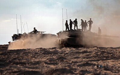 Des soldats et chars israéliens dans un champ près du kibboutz Beeri, dans le sud d'Israël, le 14 octobre 2023. (Crédit : Thomas Coex/AFP)