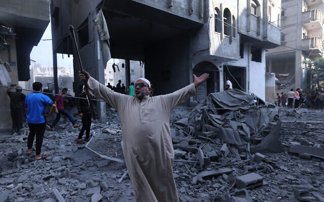 Un Palestinien dans les décombres d'un immeuble après une frappe sur le camp de réfugiés de Rafah, dans le sud de la bande de Gaza, le 17 octobre 2023. (Crédit : MOHAMMED ABED / AFP) Un Palestinien dans les décombres d'un immeuble après une frappe sur le camp de réfugiés de Rafah, dans le sud de la bande de Gaza, le 17 octobre 2023. (Crédit : MOHAMMED ABED / AFP)