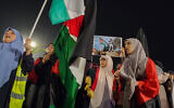 Des personnes brandissant des pancartes et des drapeaux palestiniens lors d'une manifestation à Tripoli, capitale de la Libye, le 17 octobre 2023. (Crédit : Mahmud Turkia/AFP)