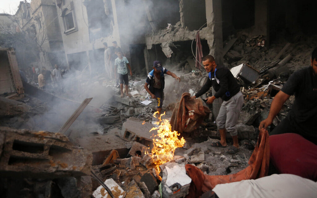 Des Palestiniens recherchent des victimes et des survivants, suite à une frappe israélienne sur la ville de Deir Al-Balah, dans le centre de la bande de Gaza, le 18 octobre 2023. (Crédit : Mohammed Faiq / AFP)
