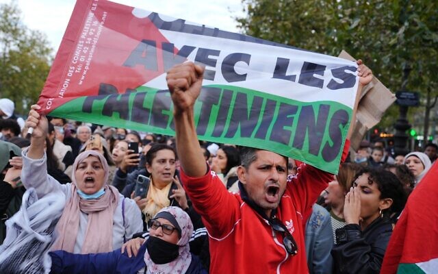 Un homme tenant un drapeau palestinien lors d'une manifestation à Paris, le 19 octobre 2023. (Crédit : Dimitar Dilkoff/AFP)