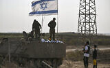 Des soldats israéliens sur un véhicule blindé déployé près de la frontière entre Israël et Gaza discutent avec un ultra-orthodoxe, le 24 octobre 2023. (Crédit : Aris Messinis /AFP)