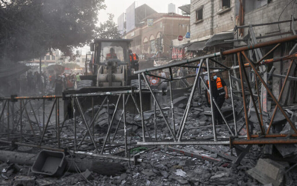 Des secouristes palestiniens nettoient les décombres d'un bâtiment suite à des frappes israéliennes nocturnes sur le camp de réfugiés de Rafah, dans le sud de la bande de Gaza, le 25 octobre 2023. (Crédit : Mohammed Abed/AFP)