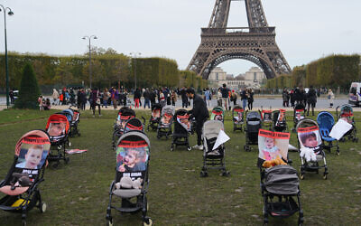 Des poussettes avec des photos de jeunes otages emmenés par les terroristes du Hamas, lors d'une manifestation pour demander leur libération au Champ de Mars, devant la Tour Eiffel, à Paris, le 26 octobre 2023. (Crédit : Dimitar DILKOFF / AFP)