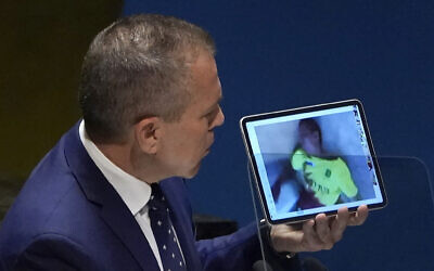 L'ambassadeur d'Israël à l'ONU, Gilad Erdan, montrant des images du massacre du 7 octobre par le Hamas, lors d'une réunion d'urgence sur la guerre entre Israël et le Hamas à l'Assemblée générale des Nations unies, à New York, le 26 octobre 2023. (Crédit : Timothy A. Clary/AFP)