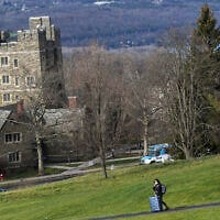 Illustration : Un étudiant de l'Université Cornell marchant avec ses bagages le long du campus à Ithaca, à New York, le 16 décembre 2021. (Crédit : Heather Ainsworth/AP)