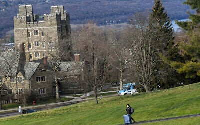 Illustration : Un étudiant de l'Université Cornell marchant avec ses bagages le long du campus à Ithaca, à New York, le 16 décembre 2021. (Crédit : Heather Ainsworth/AP)