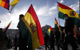 Illustration : Des manifestants brandissant des drapeaux boliviens, à La Paz, en Bolivie, le 12 janvier 2023. (Crédit : Juan Karita/AP Photo)