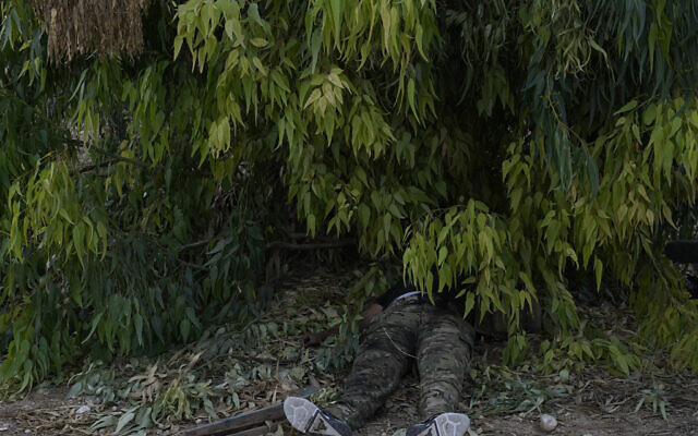 Le corps d'un terroriste du Hamas gisant sur le sol dans le kibboutz Kfar Azza, le 10 octobre 2023. (Crédit : Ohad Zwigenberg/AP Photo)
