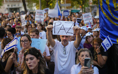 Un homme brandit un panneau où est écrit "Paix" en espagnol pendant un rassemblement pro-israélien aux abords de l'ambassade israélienne de Madrid, en Espagne, le 10 octobre 2023. (Crédit : AP Photo/Manu Fernandez)