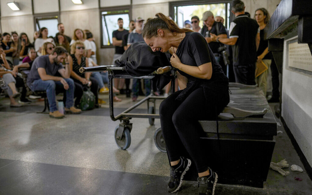 Des personnes en deuil à côté du corps de Mapal Adam, lors de ses funérailles à Tel Aviv, Israël, le 11 octobre 2023. (Crédit : Francisco Seco/AP Photo)