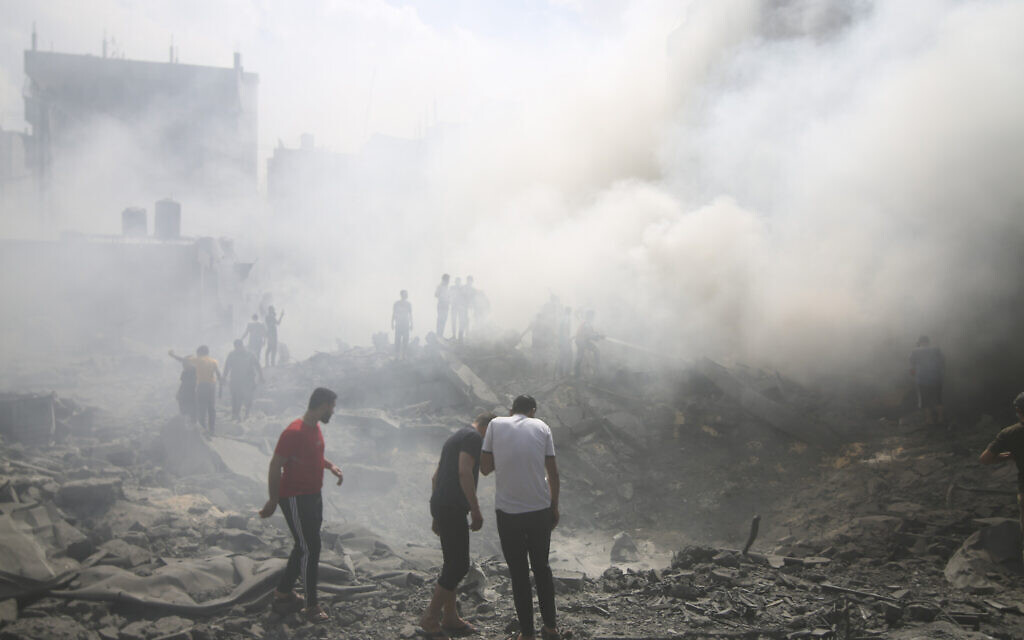 Des Palestiniens cherchant des survivants après une frappe aérienne israélienne dans le camp de réfugiés de Rafah, dans le sud de la bande de Gaza, le 12 octobre 2023. (Crédit : Hatem Ali/AP)