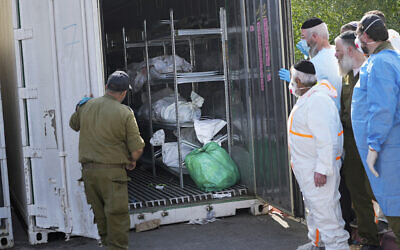 Les corps des Israéliens tués lors d'un massacre mené par le Hamas rassemblés pour identification dans une base militaire à Ramle, le 13 octobre 2023. (Crédit : Ohad Zweigenberg/AP Photo)