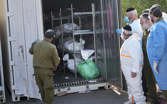 Les corps des Israéliens tués lors d'un massacre mené par le Hamas rassemblés pour identification dans une base militaire à Ramle, le 13 octobre 2023. (Crédit : Ohad Zweigenberg/AP Photo)