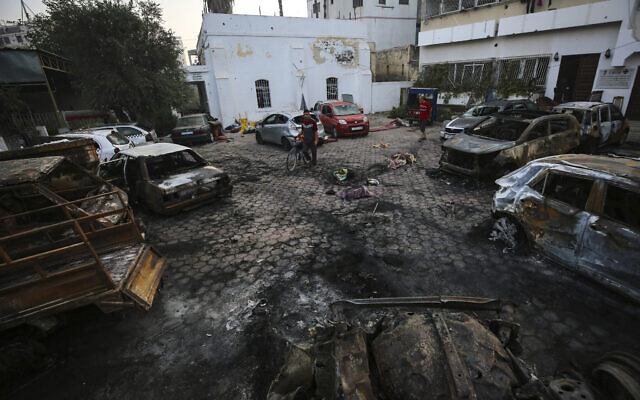 Des Palestiniens vérifiant le lieu de l'explosion à l'hôpital al-Ahli, dans la ville de Gaza, le 18 octobre 2023. (Crédit : Abed Khaled/AP)