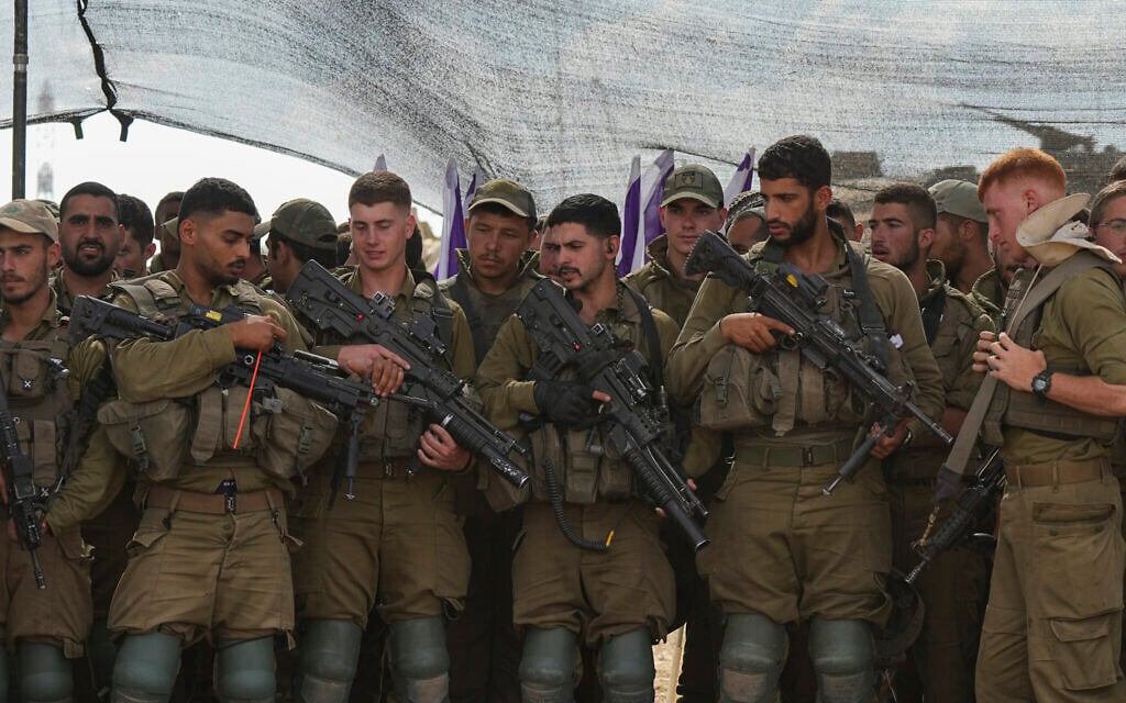 Des soldats israéliens écoutant le ministre de la Défense, Yoav Gallant, lors de sa visite d'une zone de transit près de la frontière avec la bande de Gaza, dans le sud d'Israël, le 19 octobre 2023. (Crédit : Tsafrir Abayov/AP Photo) Des soldats israéliens écoutant le ministre de la Défense, Yoav Gallant, lors de sa visite d'une zone de transit près de la frontière avec la bande de Gaza, dans le sud d'Israël, le 19 octobre 2023. (Crédit : Tsafrir Abayov/AP Photo)